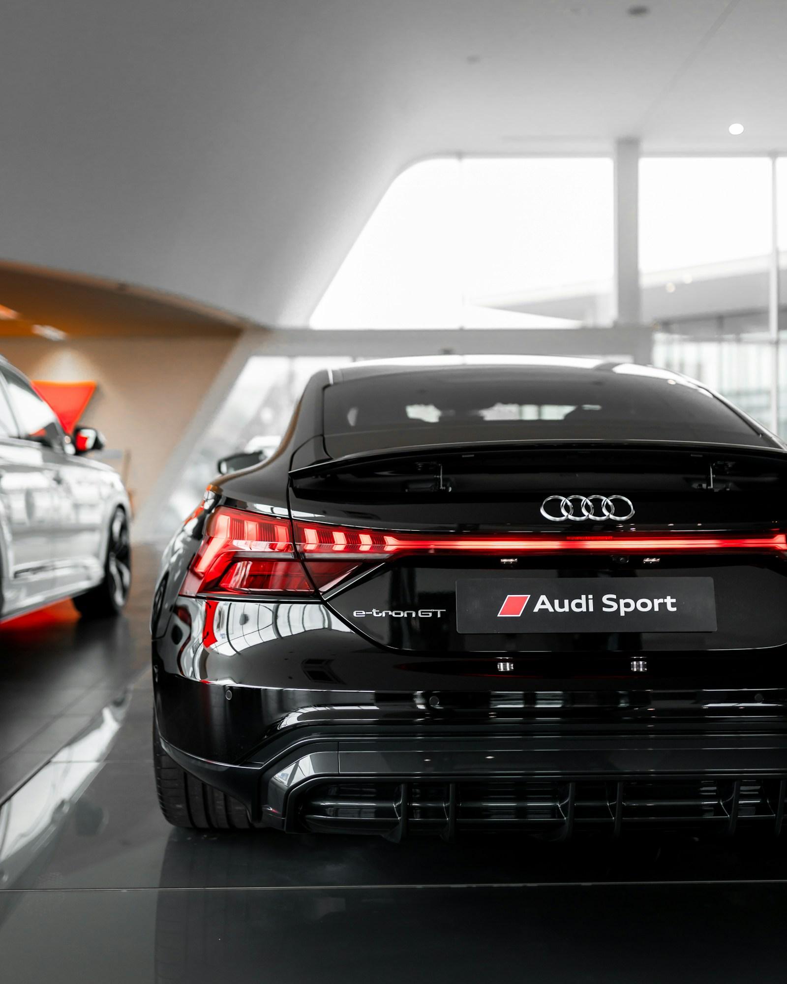 Rear of a black Audi e-tron GT with its full-width tail light lit