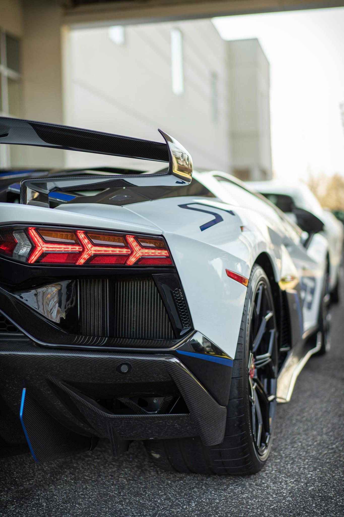 Rear quarter of a white Lamborghini Aventador with carbon-fibre wing and diffuser