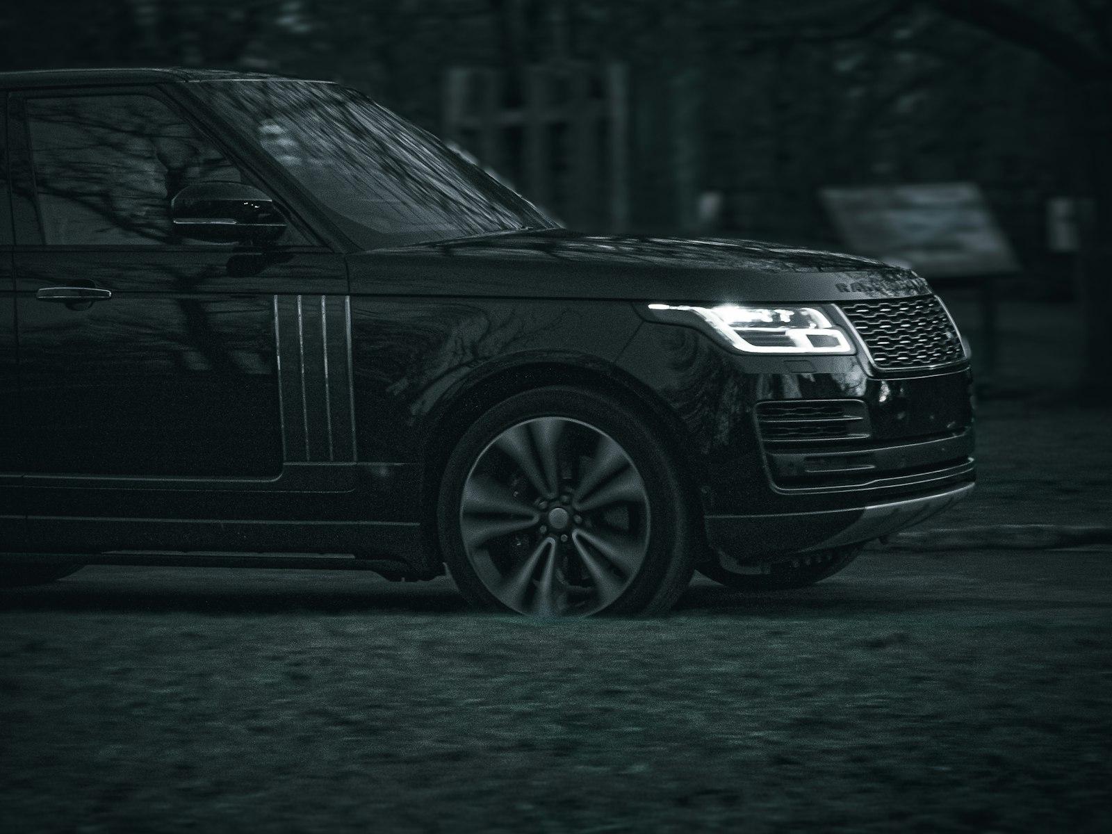 Black Range Rover front quarter at dusk with its LED headlight lit