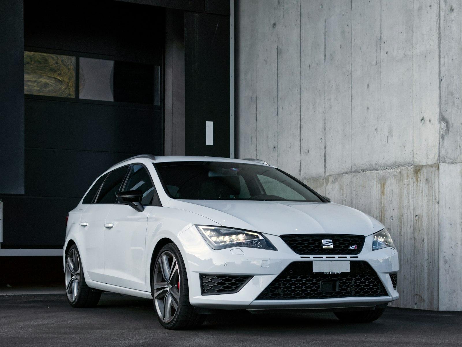 White Seat Leon ST Cupra parked against a raw concrete wall