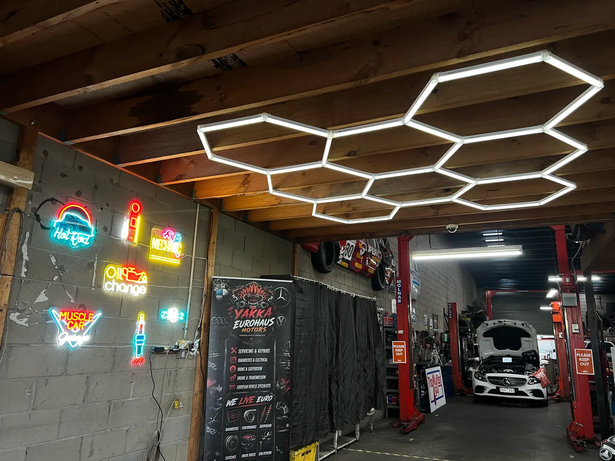 Workshop signage wall with neon garage signs and the Yakka Eurohaus banner